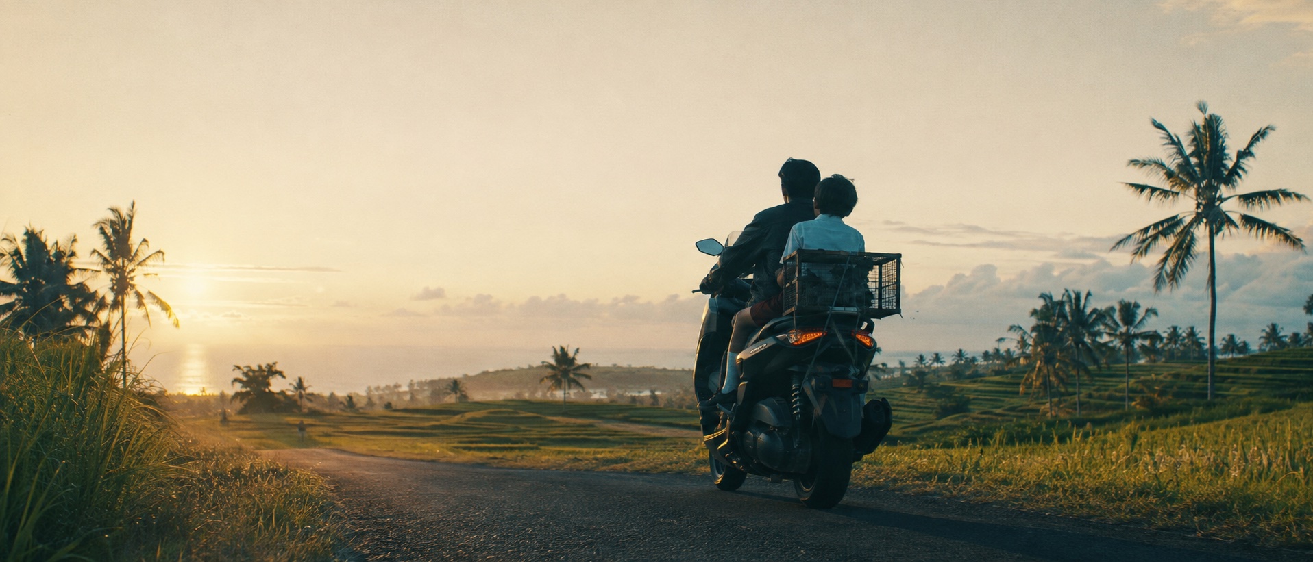 Ahmed and Nyoman ride the black maxi-scooter with Bro's cage into the sunset through Balinese rice terraces